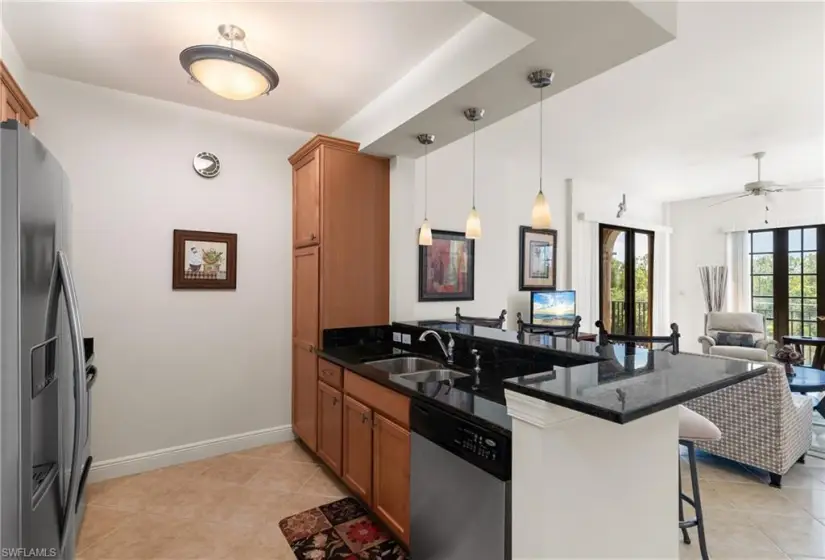 Kitchen featuring a kitchen breakfast bar, stainless steel appliances, kitchen peninsula, and light tile floors